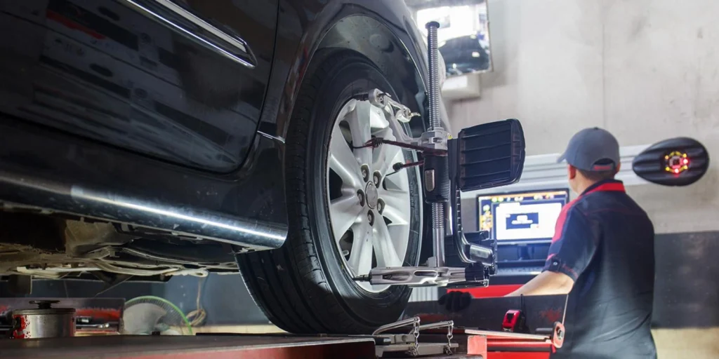 Técnico realizando alineación de ruedas en Auto Expo Houston.